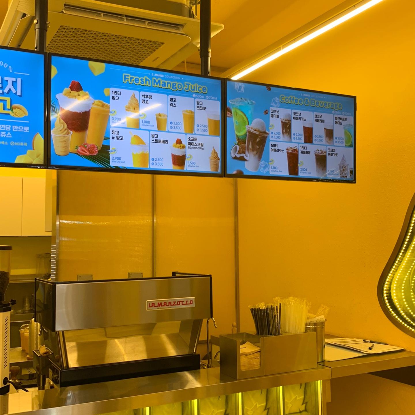 GO MANGO 카페 내부 모습. 망고 주스와 커피 메뉴가 디스플레이 되어 있는 화면.