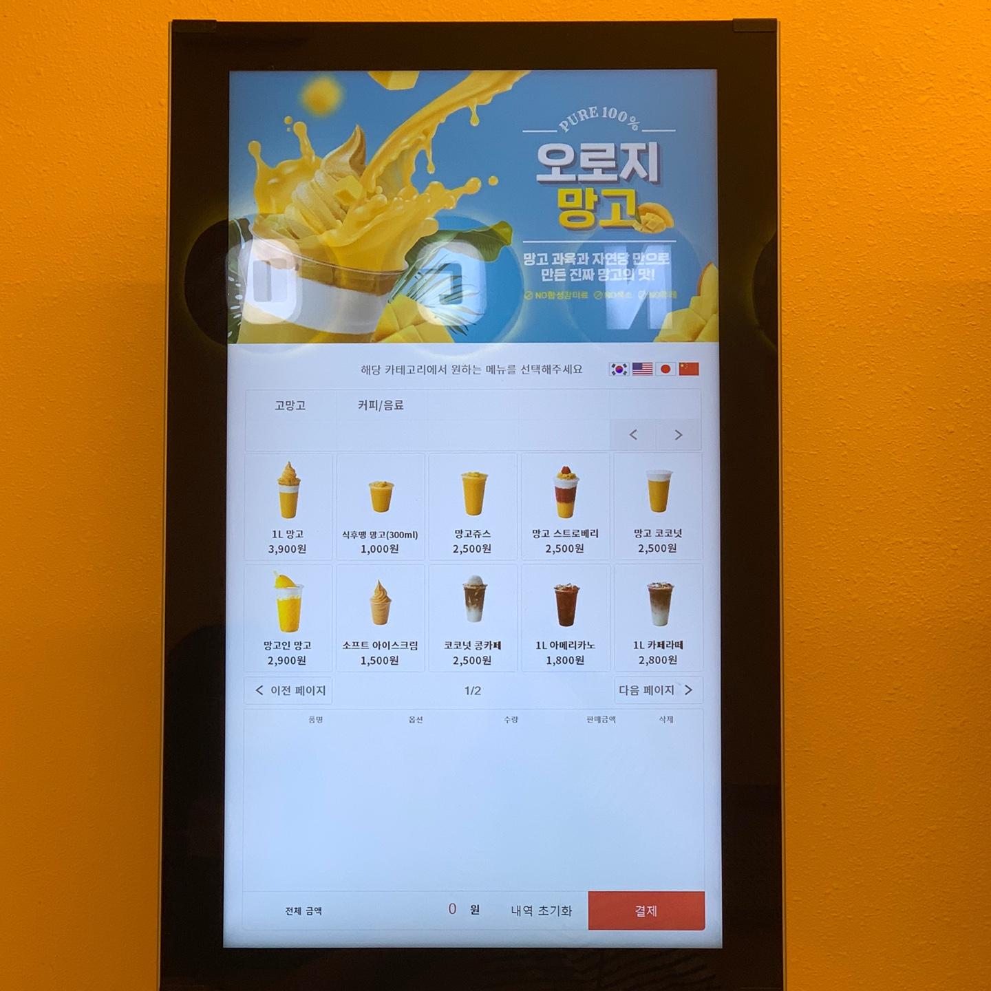 GO MANGO의 디지털 메뉴 스크린. 다양한 망고 음료와 가격이 표시되어 있음.