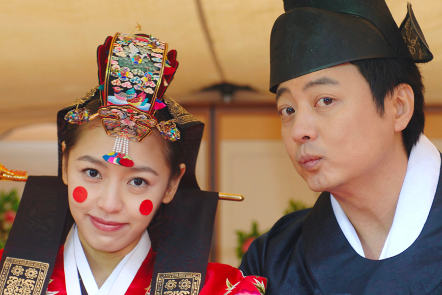 穿著朝鮮古代傳統婚禮服飾的新郎與新娘，戴著象徵福氣的裝飾物