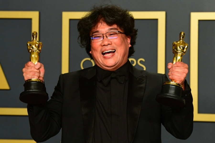 寄生上流電影的主角們在破舊的廚房桌邊坐著，展示韓國社會不平等的故事背景。