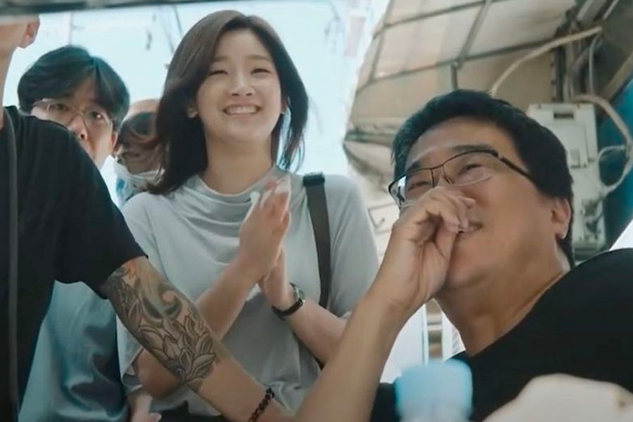 韓國導演奉俊昊手持奧斯卡獎杯，穿著黑色西裝，慶祝《寄生上流》獲得奧斯卡殊榮的時刻。