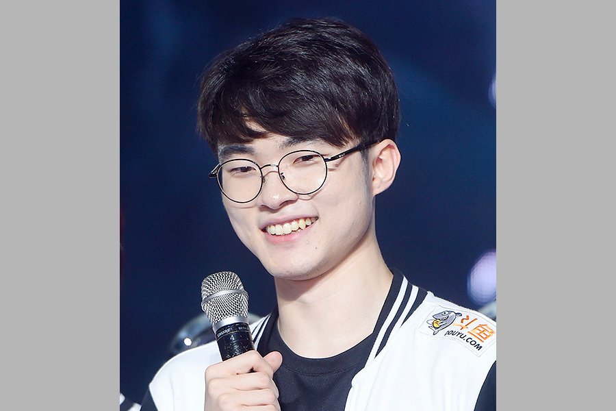 韓國電競選手Faker手持麥克風，展示他在英雄聯盟項目中的卓越技能和韓國電競的代表性。