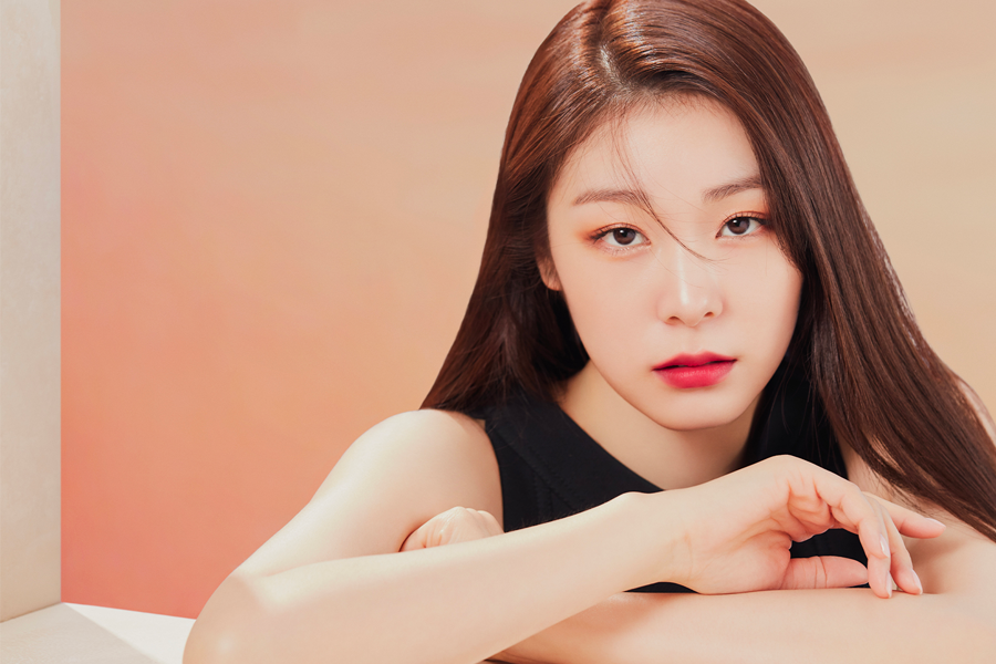 韓國花樣滑冰女王金妍兒穿著黑色衣服，笑容滿面，展現她的優雅和時尚魅力。