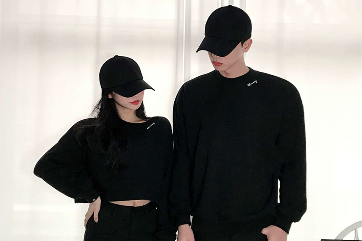 全黑帽衫和帽子情侶裝，展現韓國潮流中的簡約與酷感。