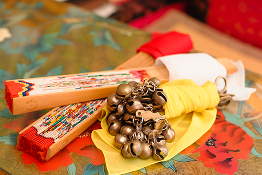 韓國傳統巫術用具展示，包括繪有圖案的木製板和金屬鈴鐺，用作占卜和除靈儀式。