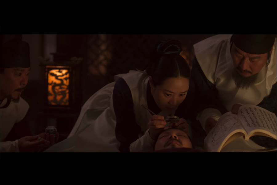 韓國電影《觀相大師》中的場景，描述觀相大師正在研究面相書籍及做筆記。