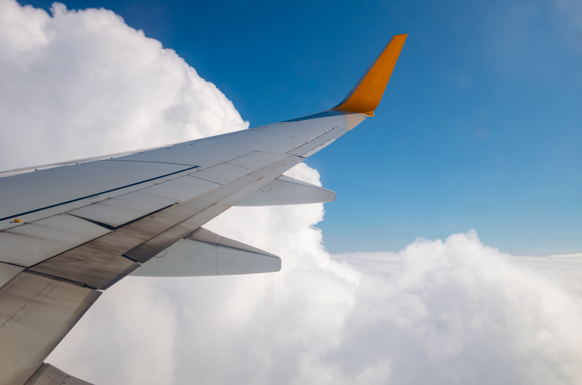 飛行機の翼が空中を飛ぶ様子、韓国での夢佔いで飛行をテーマにした夢の象徴的なイメージ