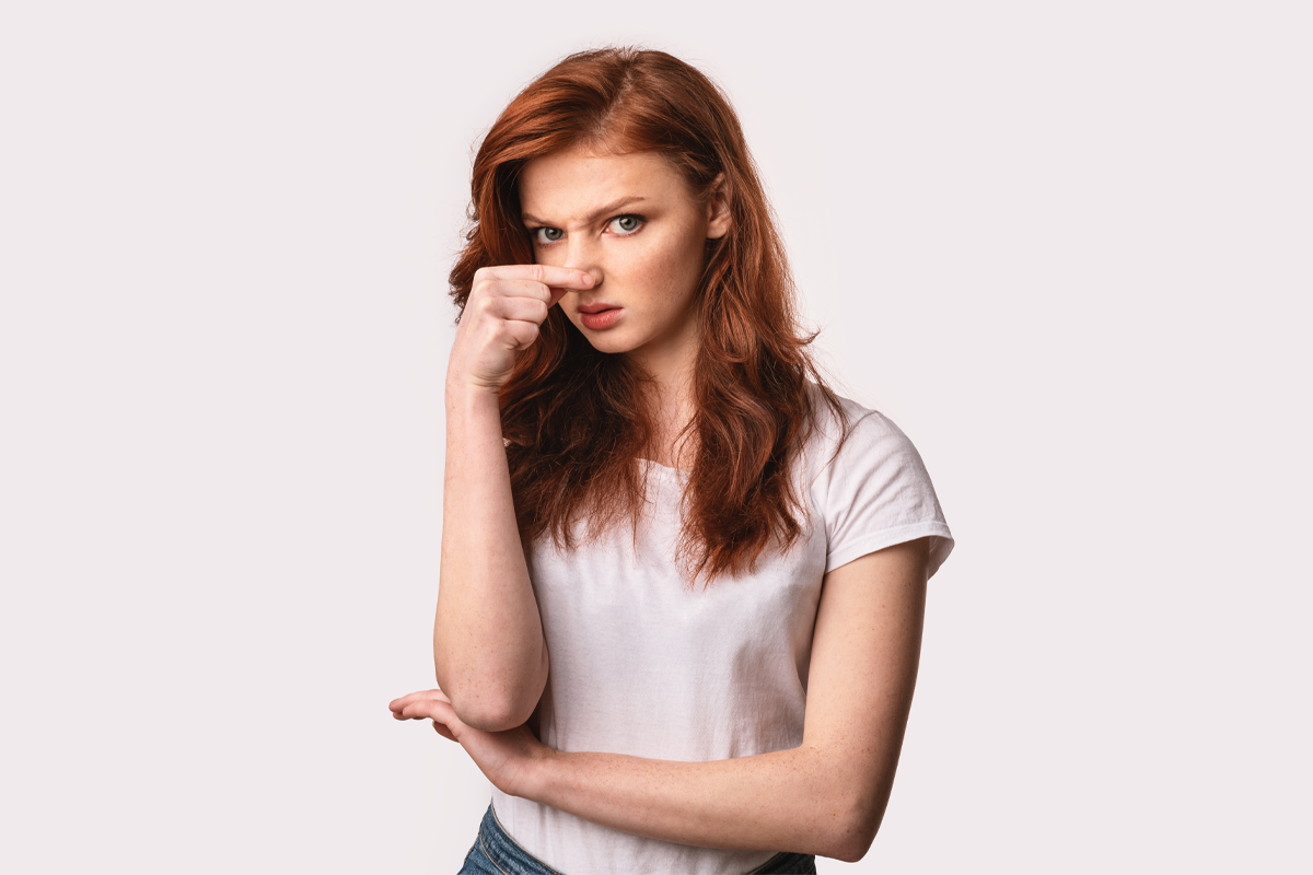 一個紅髮女性站著，背景是白色的，夢境可能象徵著獲得財富。