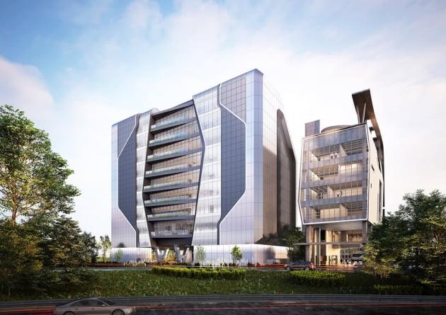 緑の木々で囲まれたYG新社屋。洗練された外観が静かに立っている風景。