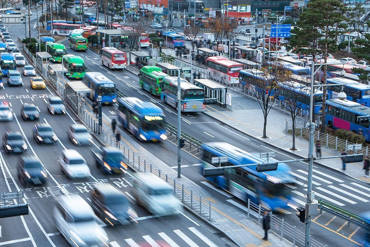 繁忙的韓國城市交通景象，展示公共交通工具的多樣性和街道活力。