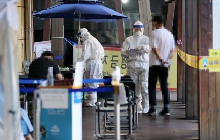 ソウルの選別診療所で、防護服を着た医療スタッフが市民を案内している光景。新型コロナウイルスの検査のため多くの人が訪れている。2020年9月24日撮影。