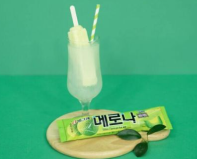 メロナアイスと一緒に飲むメロナ酒、クリアグラスにアイスが立ち、メロナのパッケージも見えるデザインです。