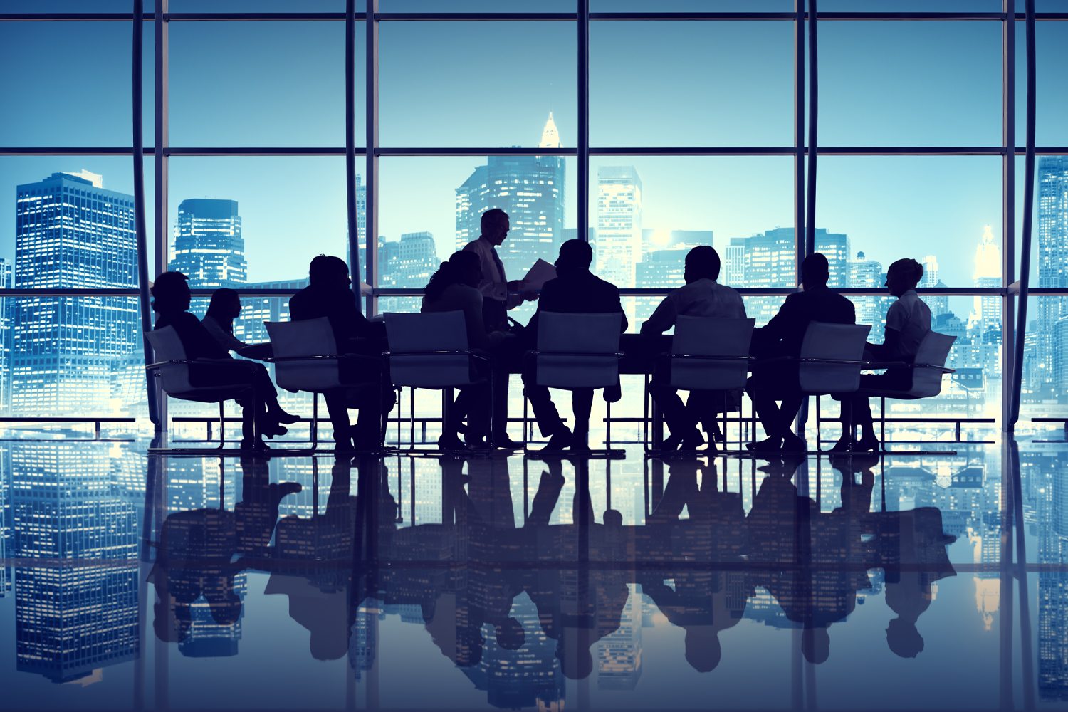 一羣人在會議室開會，背景是一座現代化城市天際線，傳遞出專業與商業氛圍。