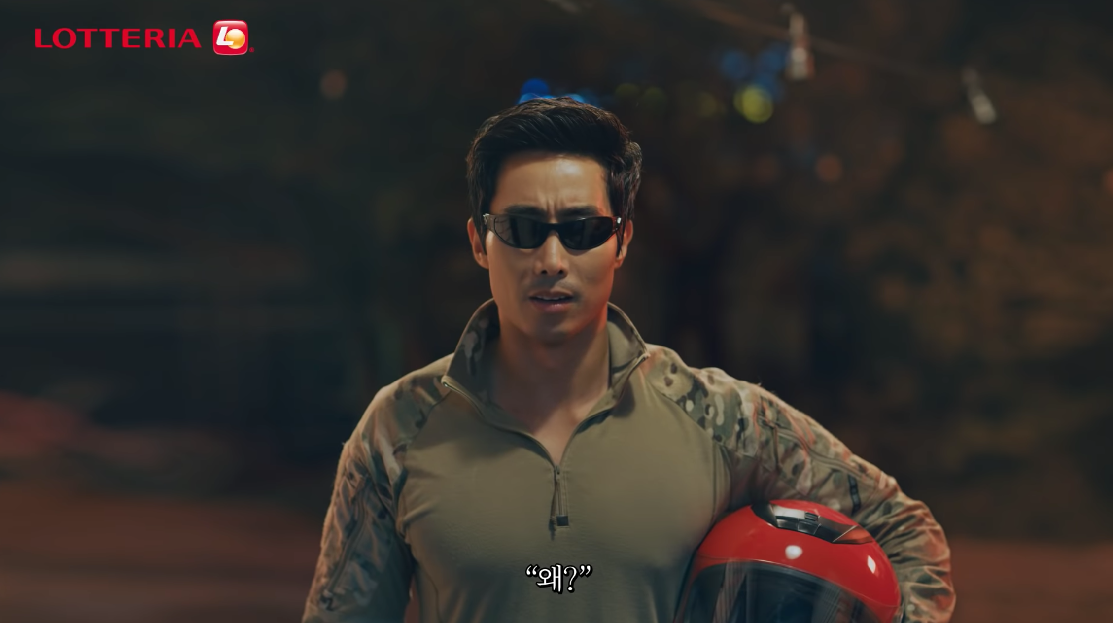 背景展示Lotteria廣告中的場景，人物互動與軍隊漢堡的推銷。