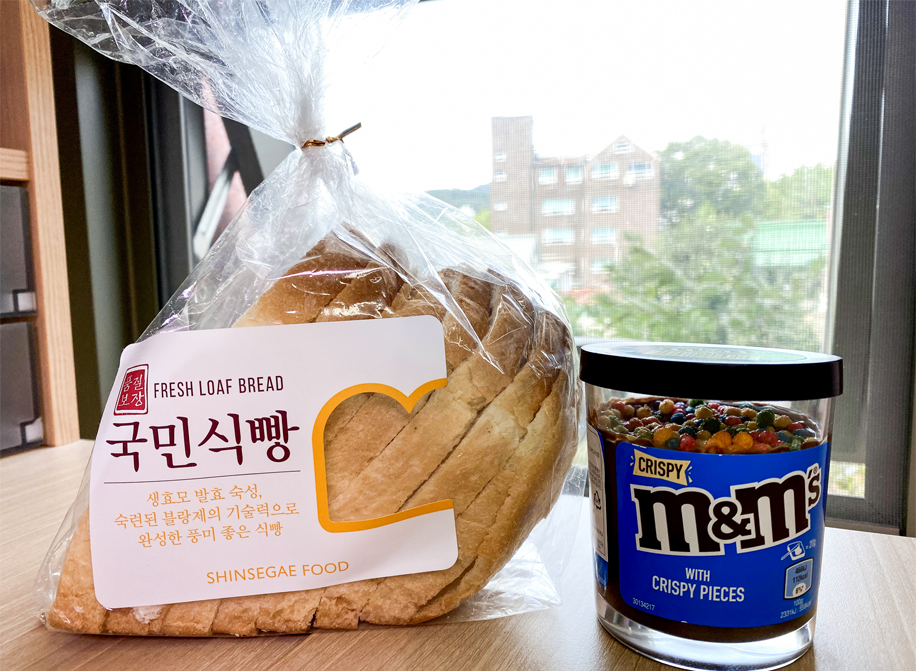 서울 제과 빵과 M&M 초콜릿 스프레드가 함께 있는 홍콩의 자연 테이블 배경