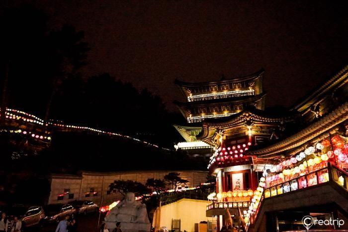 A traditional procession with performers dressed in vibrant costumes, celebrating the Busan Lantern Festival.