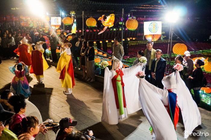 Guests walking along a wooden path with the soft glow of lanterns as a backdrop during the festival.
