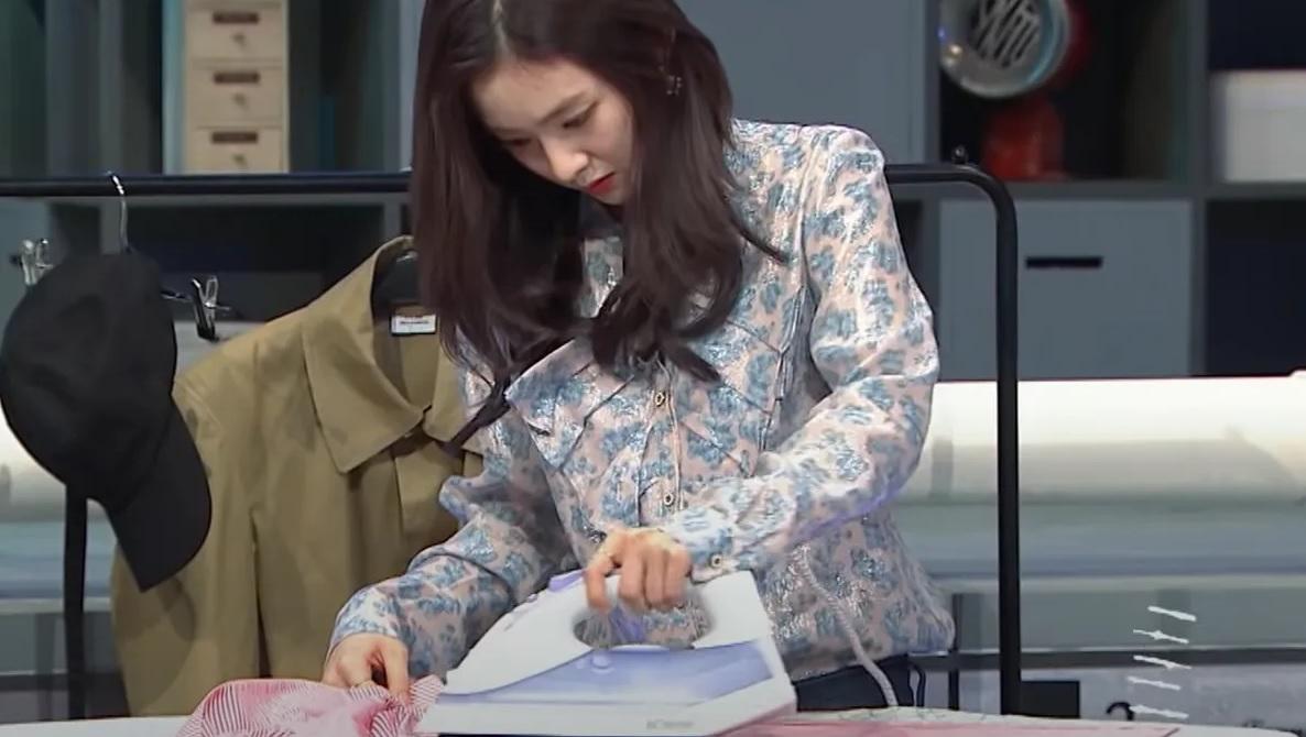 ไอดอลหญิงสวมเสื้อที่มีลวดลายสวยงามพร้อมกับรีดผ้าเป็นส่วนหนึ่งของกิจกรรมในรายการทีวี