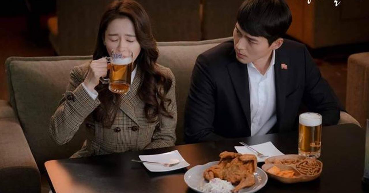 情侶在餐廳共進晚餐，桌上放著炸雞和啤酒，兩人似乎正在慶祝。