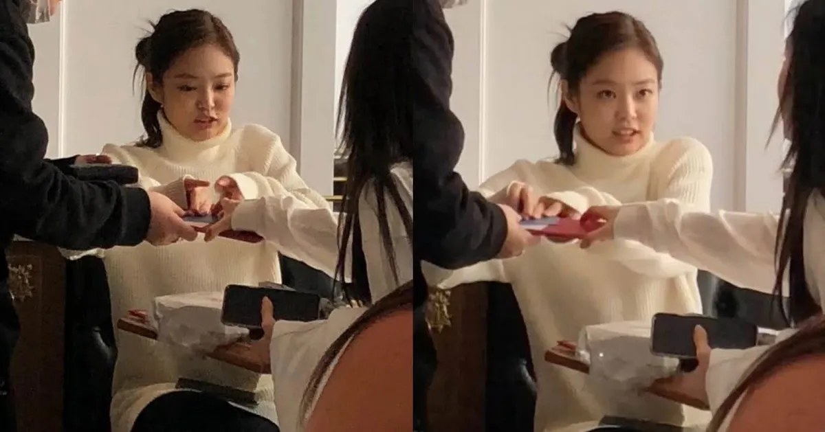 女士在餐廳結帳，服務員將小賬單遞給她，呈現付款場景。