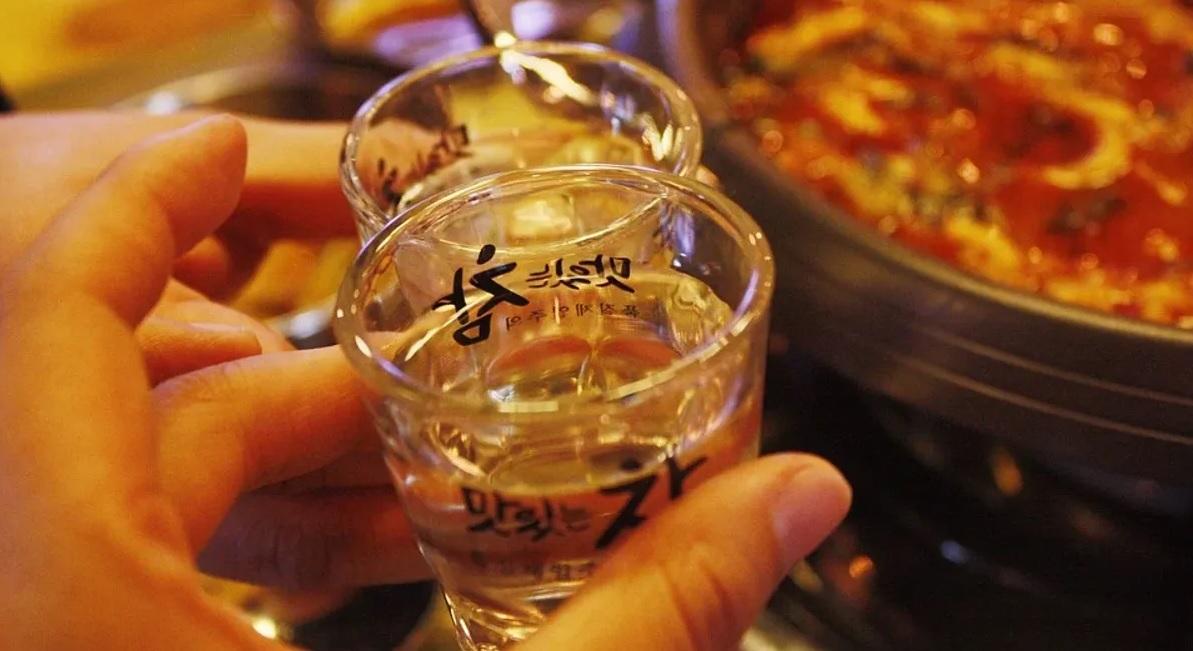 การดื่มเครื่องดื่มเกาหลีในหมู่เพื่อนร่วมระดับบรรยากาศที่อบอุ่นและเป็นกันเองในร้านอาหารเกาหลี