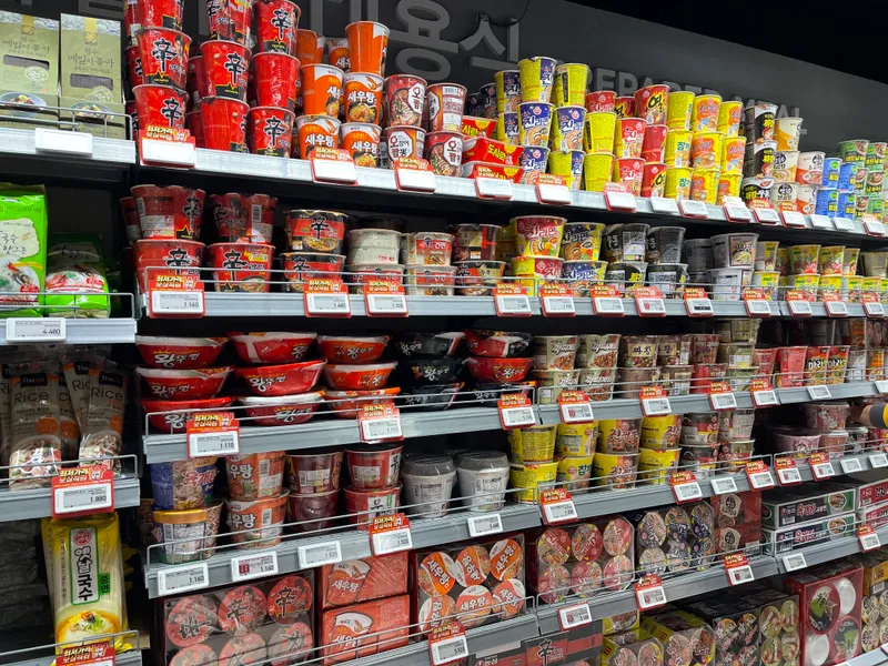 emart 新村店內展示了多樣的即食碗裝泡麵，是忙碌日常中的理想選擇。