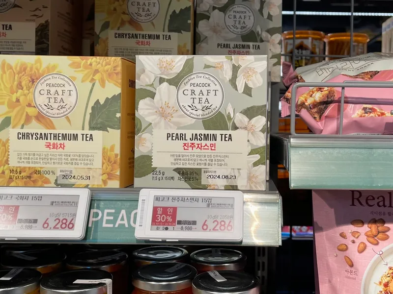 在新村 emart 的茶品和食品展架上，以促銷價展示的仿古典風味的珍珠茉莉茶，吸引愛茶人士。