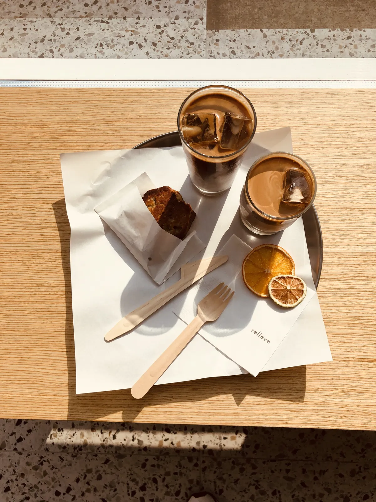 เครื่องดื่มกาแฟและขนมในร้านคาเฟ่ชื่อดังย่านยอนนัม แสดงถึงความใส่ใจในรายละเอียดและการจัดวางที่เรียบง่ายแต่ดูมีสไตล์ในบรรยากาศสบายๆ