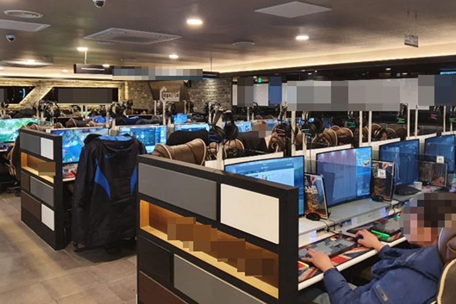 多人進行遊戲的韓國網吧現場，顯示玩家在電腦前享受遊戲的場景。