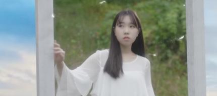 白いドレスを着て庭園に立ち、手に窓のフレームを持つ女性。