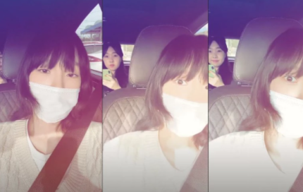 車の中で安全ベルトを装着してマスクを着用している女性。