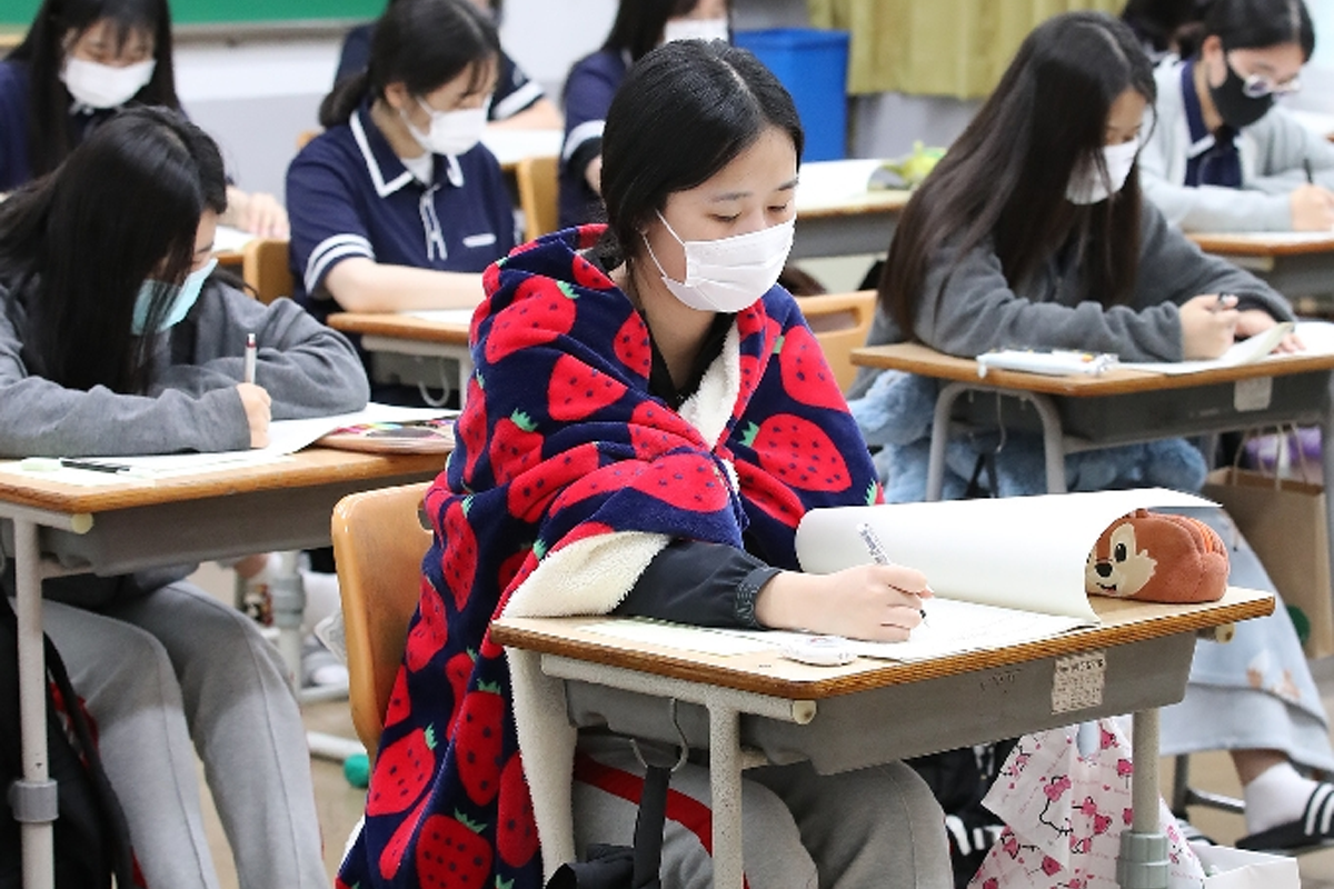 韓國中學生在課室中使用毛氈和枕頭坐著或趴著上課, 彰顯韓國校園文化中的舒適學習環境。
