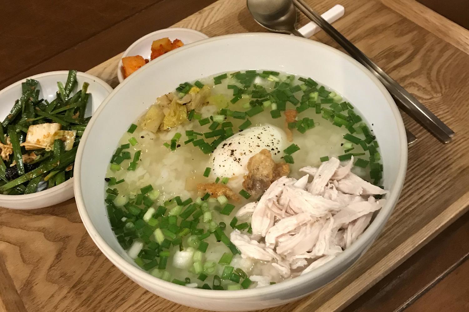 望遠洞地鐵站附近餐廳提供的韓式雞肉湯飯，湯底清澈，上面撒有葱花，搭配韓式小菜，呈現傳統韓國風味，適合學生及情侶享用的高性價比餐點。