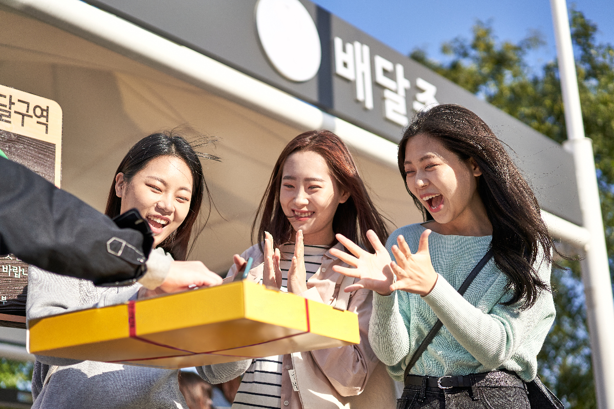 韓国でのデリバリーサービス受取地点で商品を受け取る人々。