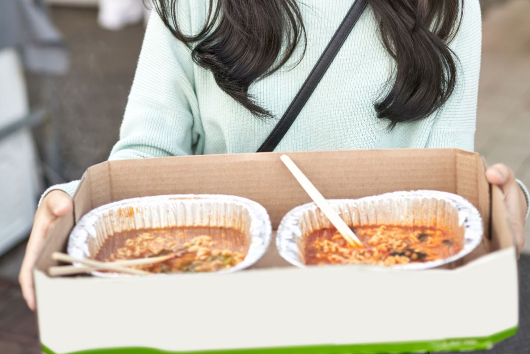 韓国の公園で出来上がったラーメンを持っている姿。