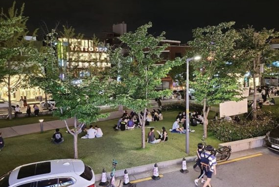 夜の韓国のヨントラルパークで集まる人々の様子。