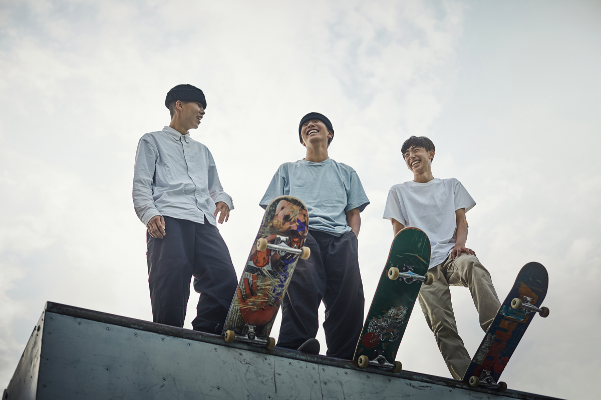 秋の公園の紅葉の中を犬と歩く人。