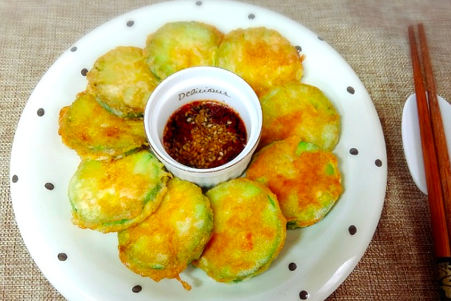 栉瓜煎饼围绕盘子，中心放置搭配的酱料，传统韩国小吃