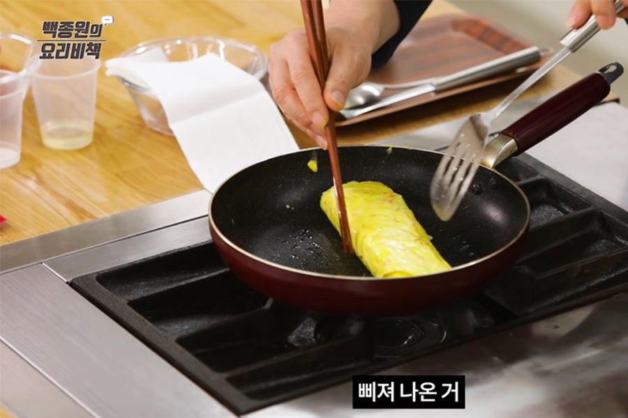 煎鸡蛋卷的尾部逐渐定型，使其保持形状