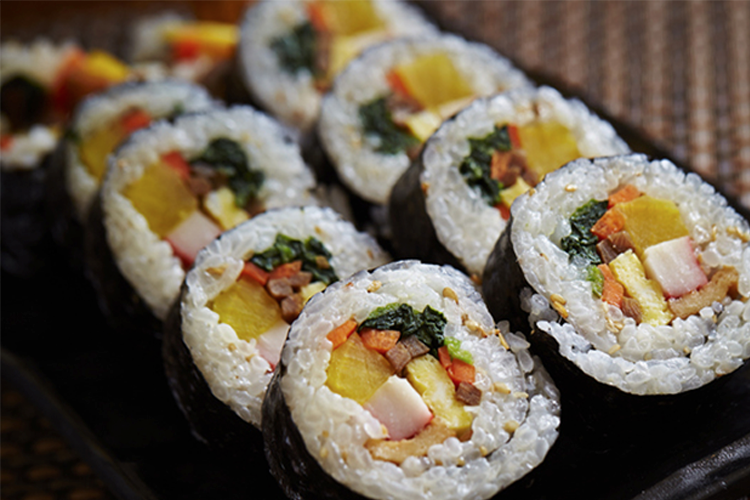 紫菜包裹的飯捲，裡面填滿色彩繽紛的蔬菜與蛋，切面整齊可見米飯與配料的層次感。