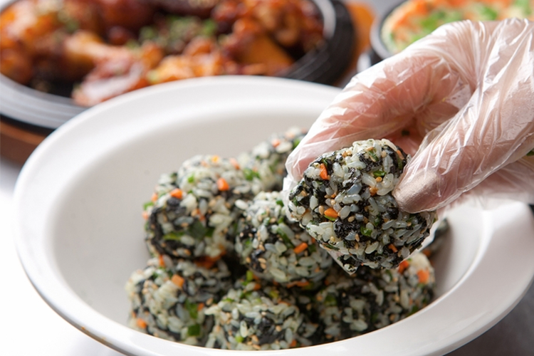 在碗中準備的韓式手抓飯，上面灑滿了芝麻與海苔碎片，香氣十足。