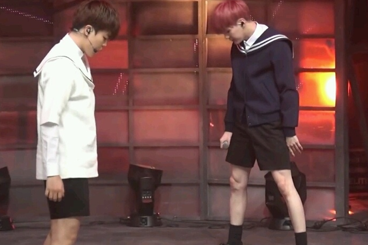 舞台表演中两位男生穿着水手服和短裤，视觉效果拉长腿部比例。