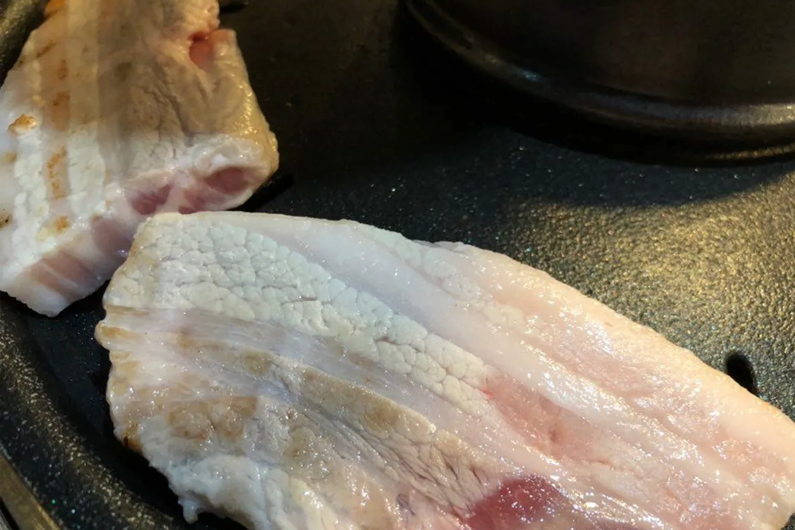 韩国首尔炭火烤肉上的三层肉,是韩国经典街头美食的一部分。