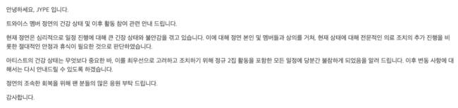 黒いドレスとゴールドのベルトを身に着けた女性、片手を上げてポーズを取っている。