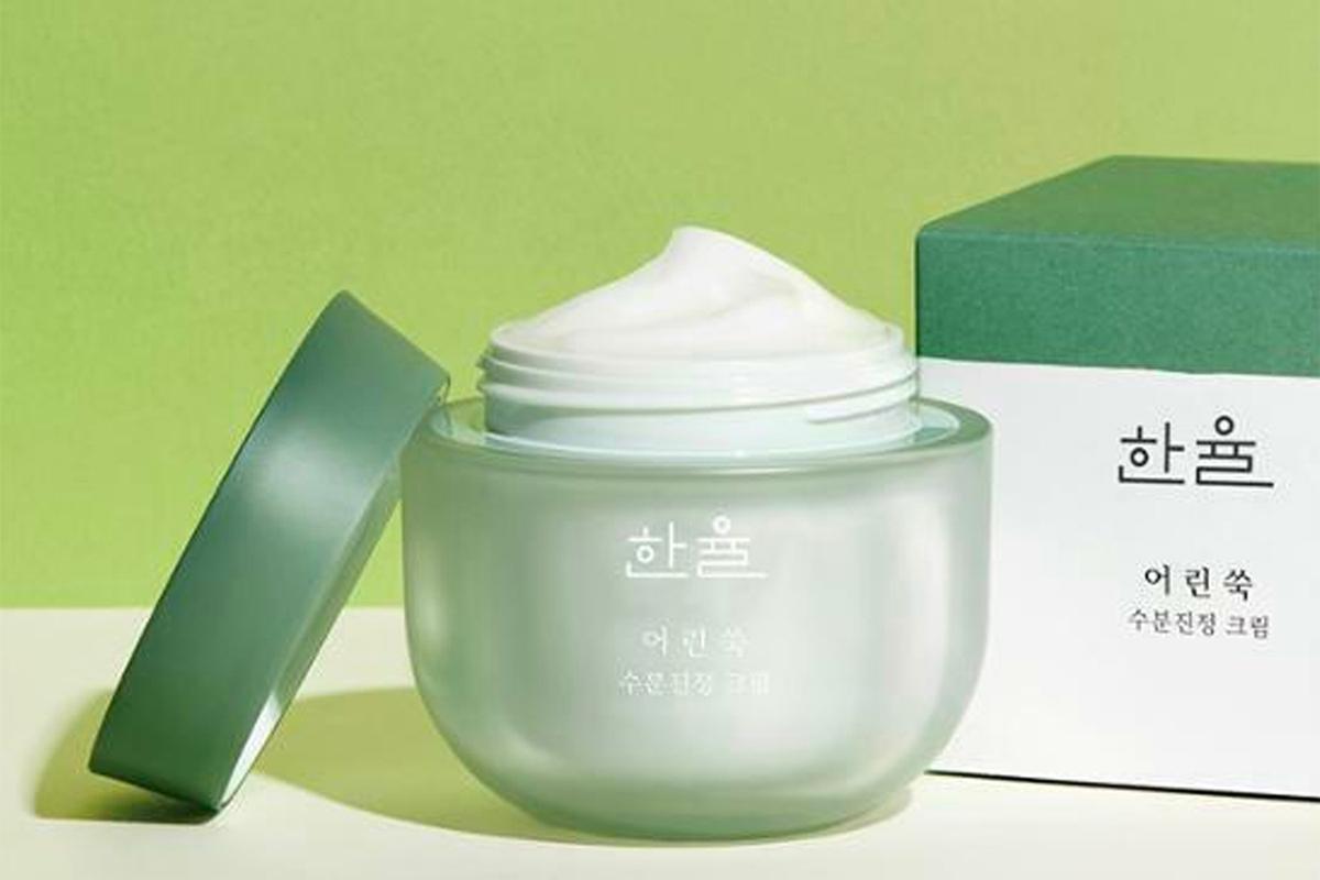 韓國護膚品牌HanYul面霜，展示的綠色瓶子打開蓋子可見乳霜，背景為綠色盒子。