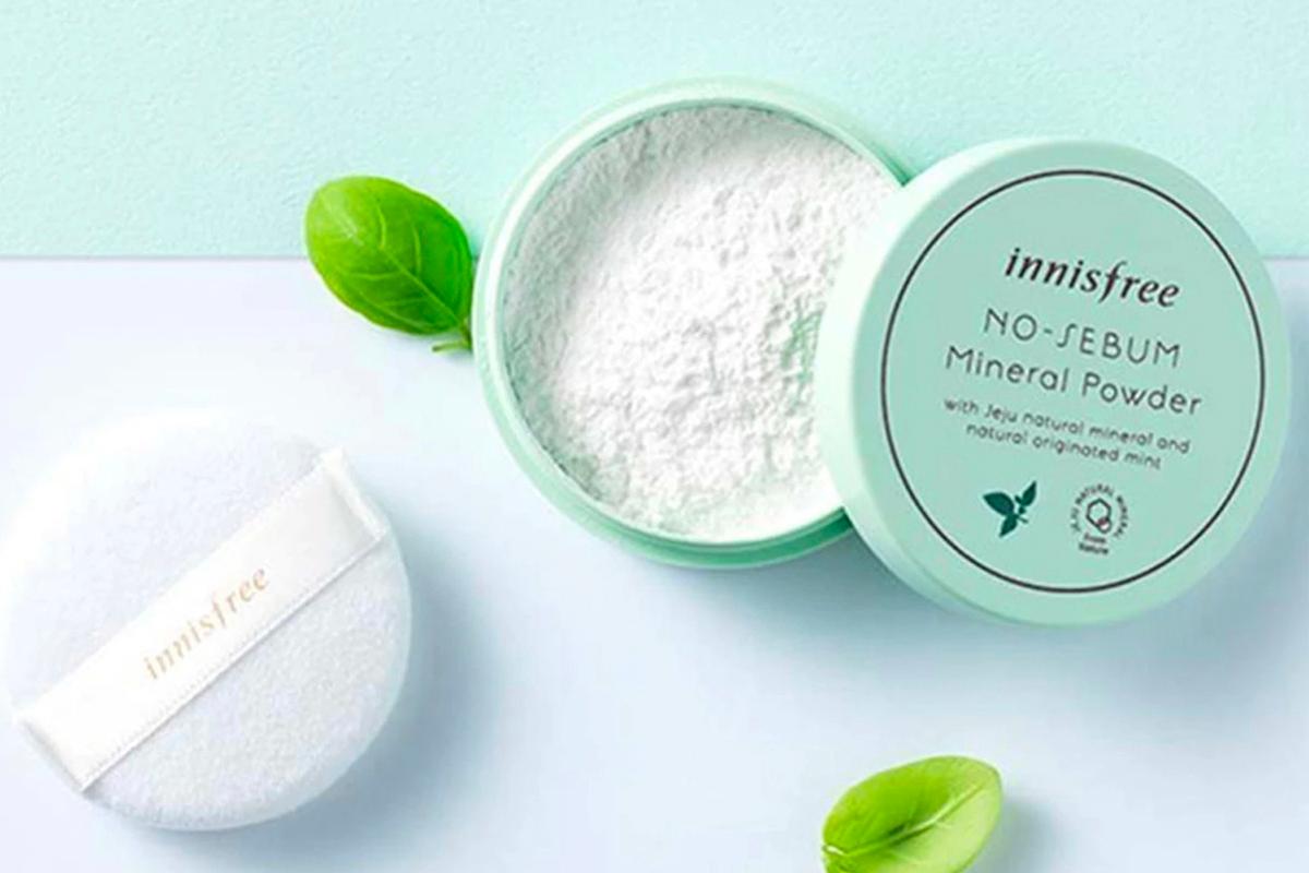 Innisfree無皮脂礦物粉末開蓋展示，背景搭配綠色葉子，提供控油及清爽功能。