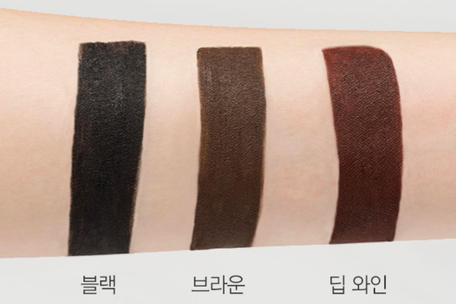 Drei farbige Swatches des MISSHA Palette Paint Liners in den Farbtönen Schwarz, Braun und Tiefweinrot auf einem Arm, zur Demonstration der Pigmentierung.