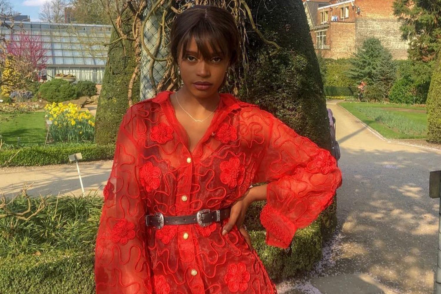 Fatou身穿紅色衣服在花園中的照片