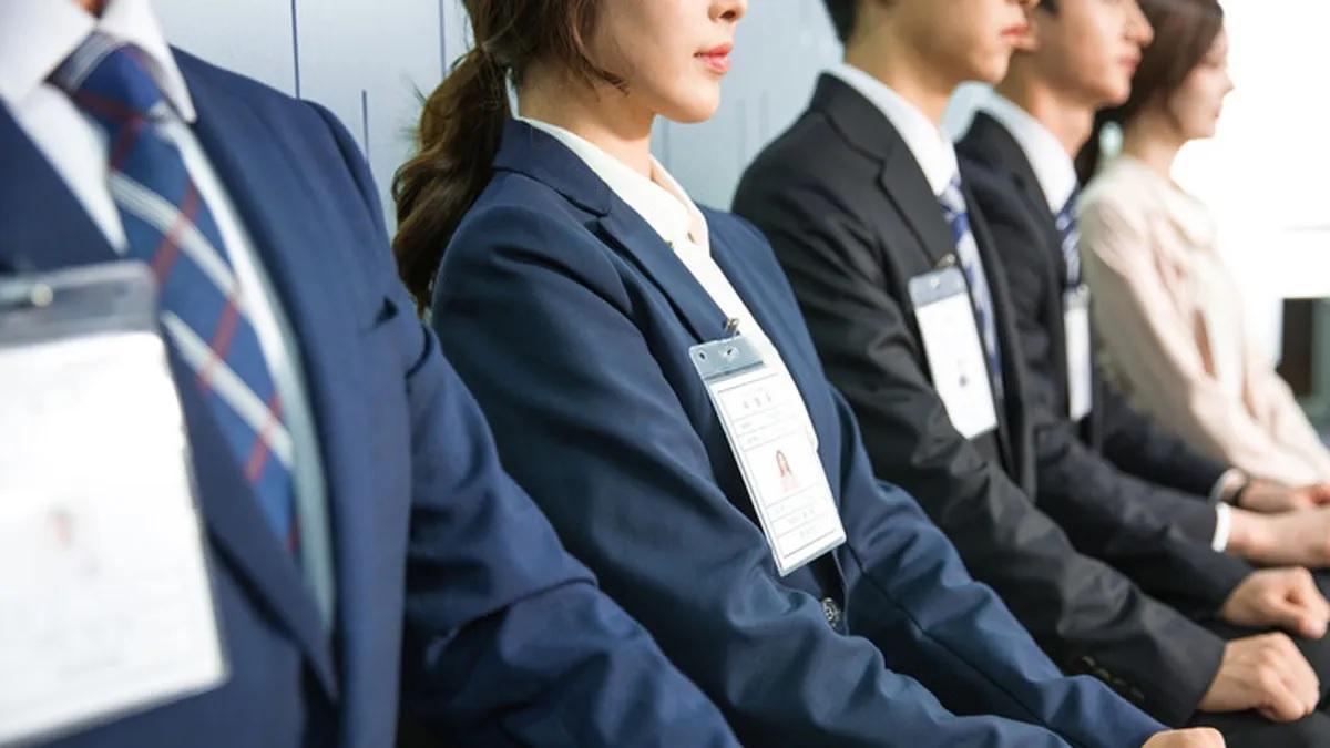 ผู้สมัครงานที่เกาหลีในชุดสูทนั่งเรียงแถวเตรียมสัมภาษณ์งานในเกาหลี