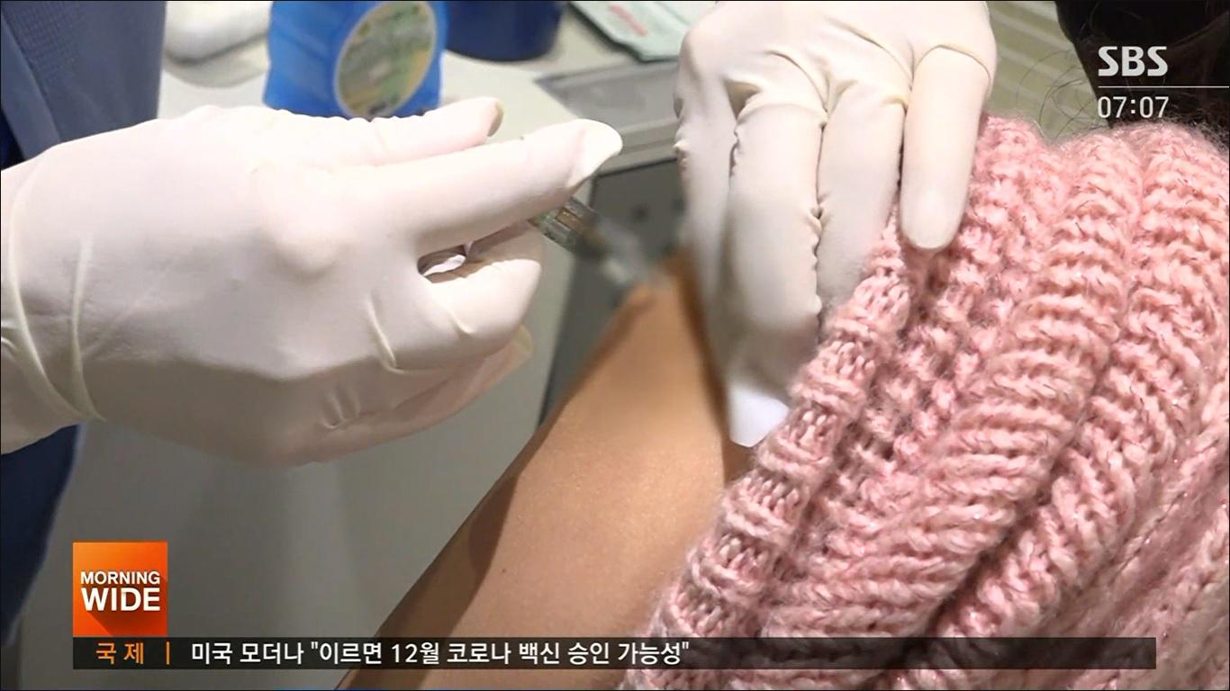 ภาพแสดงการสวมถุงมือยางที่สะอาด กำลังทำการฉีดยาลงบนแขนของผู้สวมใส่เสื้อกันหนาวสีชมพู ตอนเช้าเป็นเวลาวัคซีน